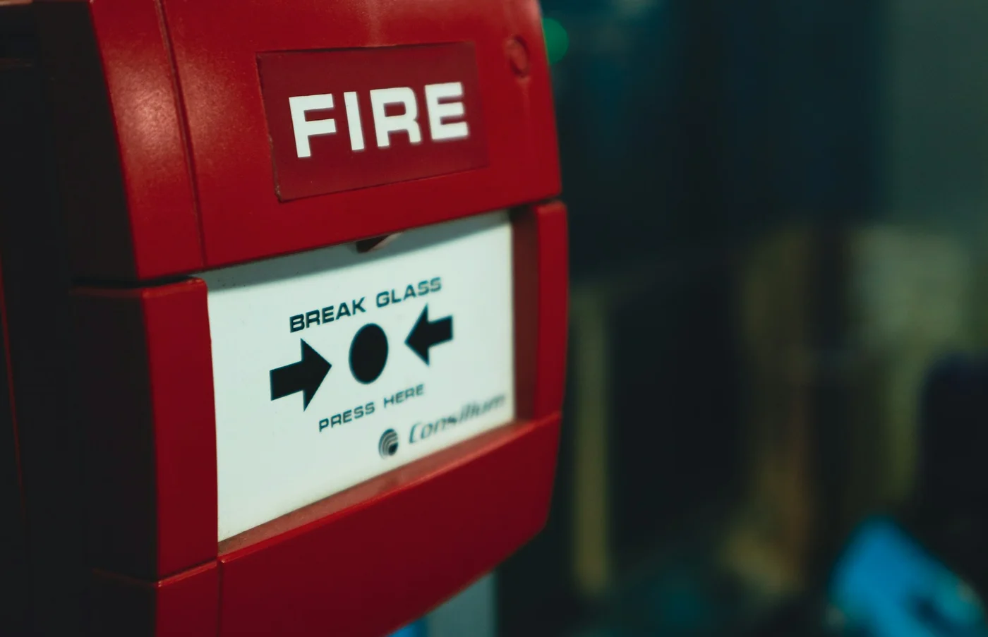 Red fire alarm call point mounted on a wall